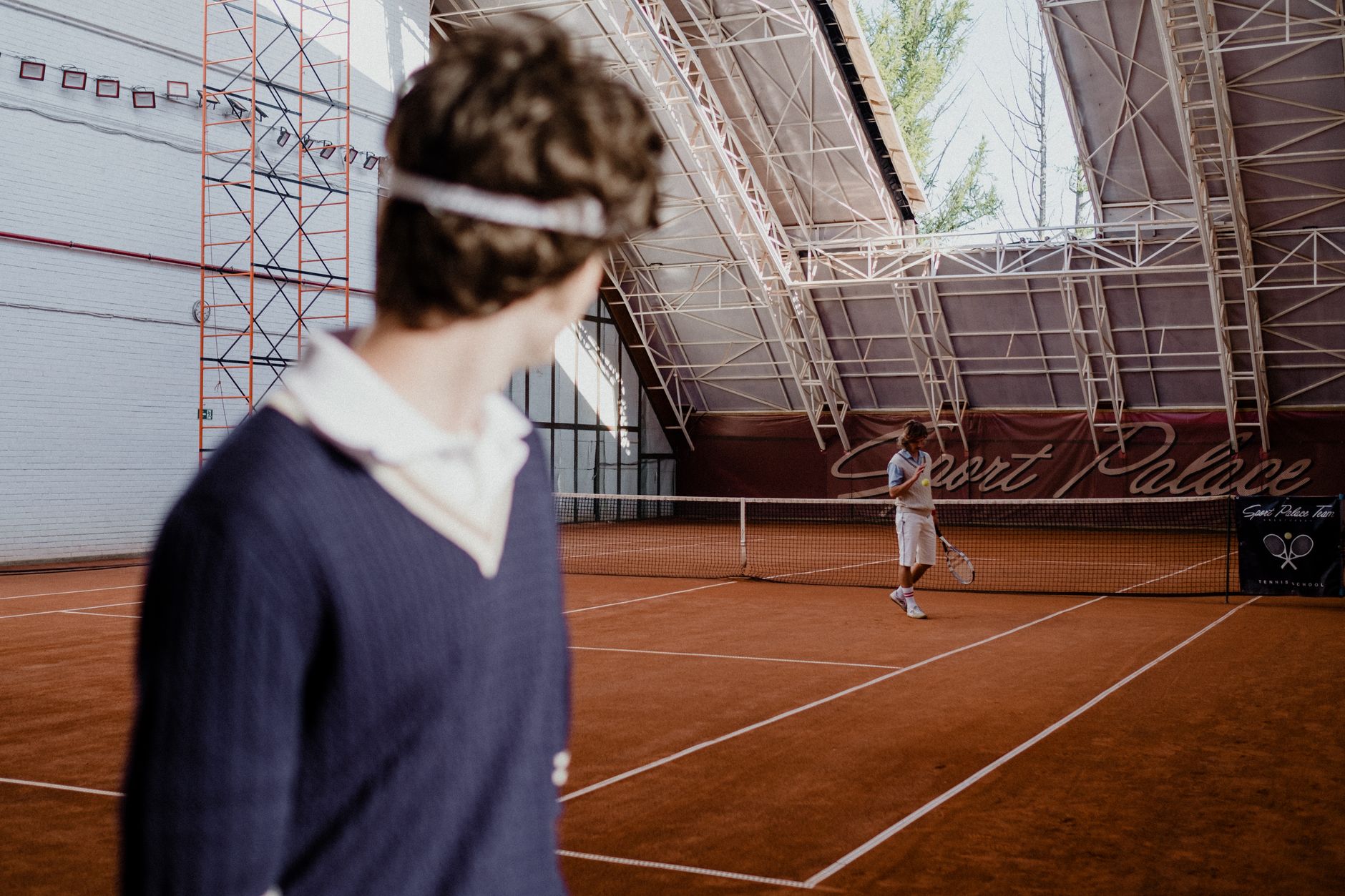 Player and tennis court viewed through a net